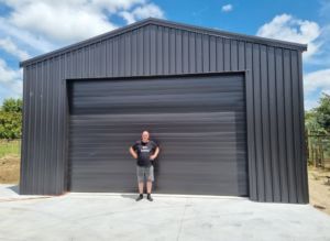large steel boat storage shed with owner in front