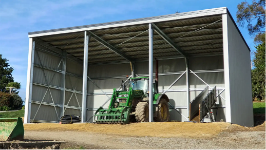 farm shed in new zealand with a parked heavy machinery